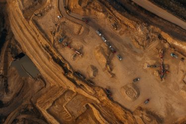 Aerial shot of an active mining site in England, showcasing natural deposits and excavation equipment.
